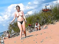 The view of a lady with big melons walking along the beach can?t leave you indifferent
